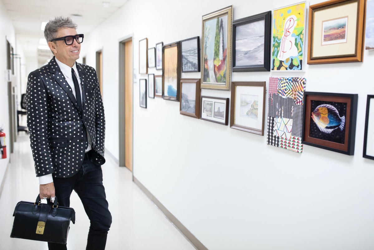 Bedlack looking at art on the walls of the hallway in his clinic