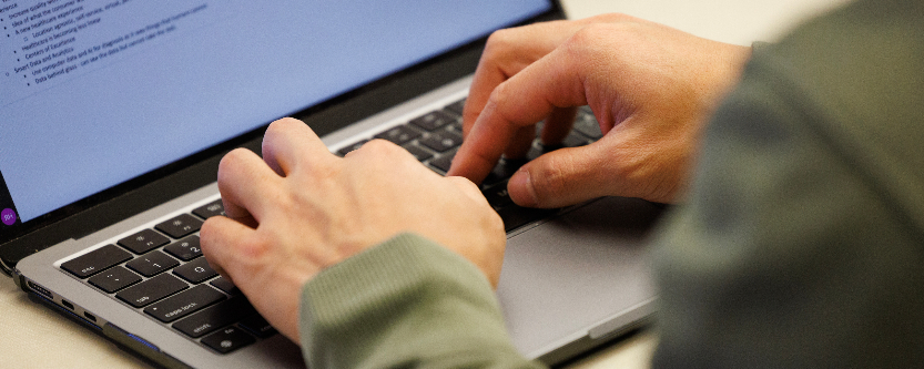 Hands typing on computer
