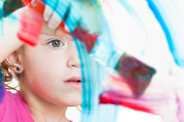 Stock image of young girl painting on glass