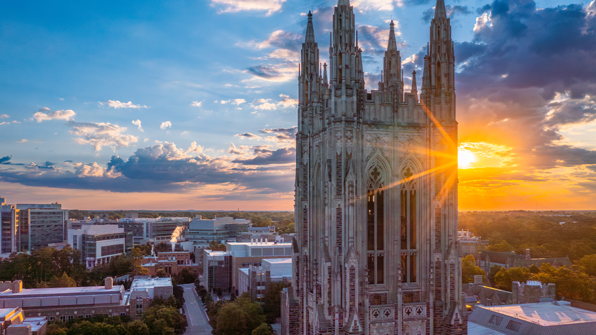 chapel tower against a setting sun with the Duke Medical campus in the background
